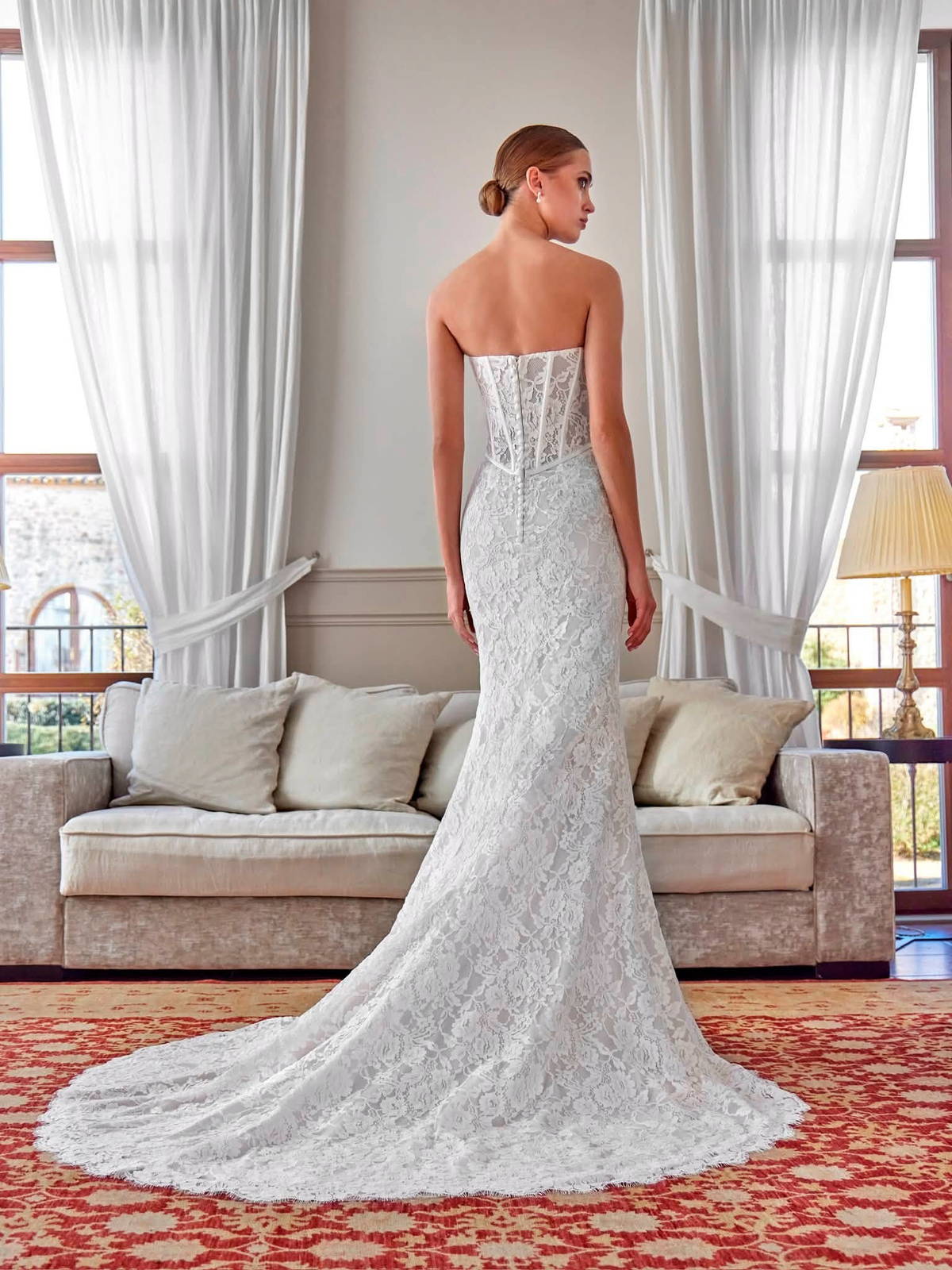 Dos d’une robe de mariée en dentelle, bustier corseté et longue traîne, à louer à Saint-Dizier